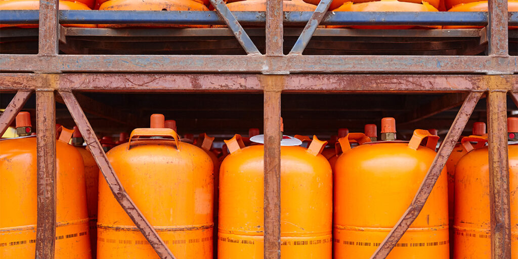 many orange metal bio-gas storage tanks together in metal cages