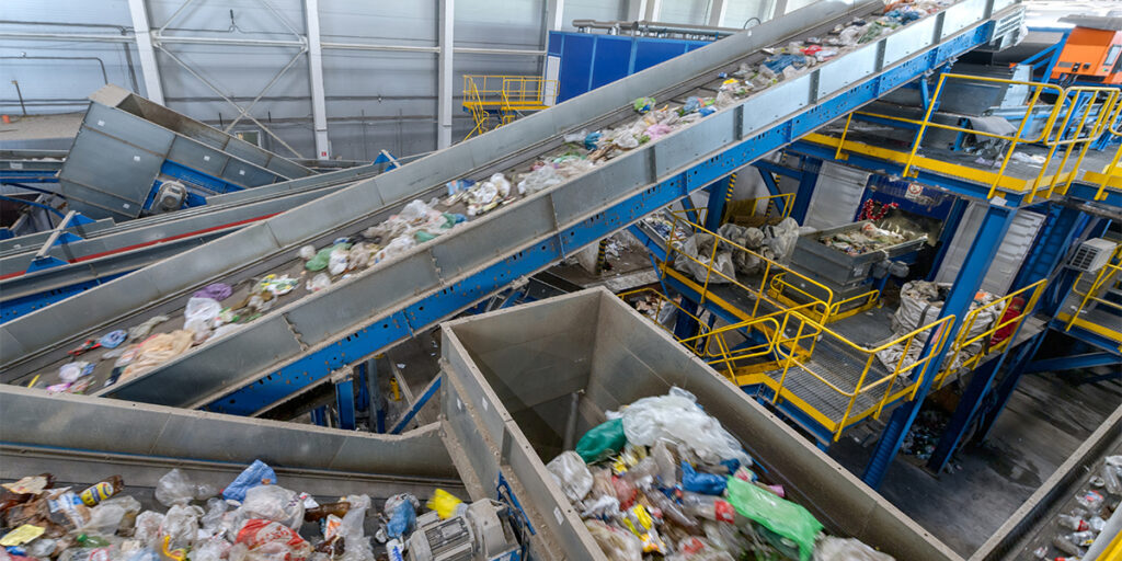 conveyor belts in a large warehouse that is separating and sorting municipal solid waste to be used as gasifier feedstock instead of going to landfills.